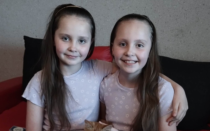 Młoda kobieta leżąca w łóżku, z uśmiechem na twarzy.