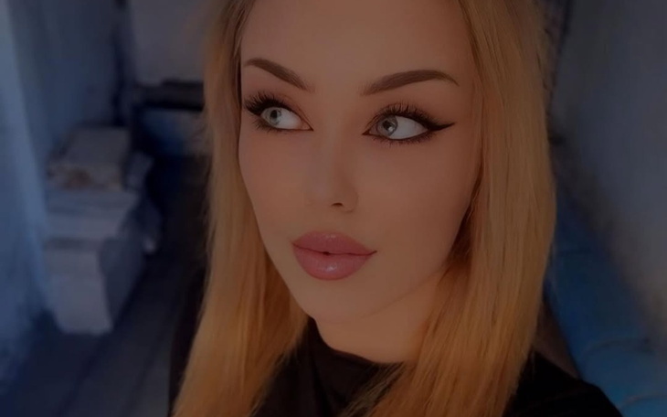 Portret kobiety z długimi blond włosami i wyrazistym makijażem.
