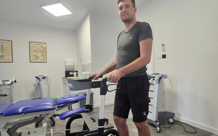 Mężczyzna przy sprzęcie rehabilitacyjnym w gabinecie.