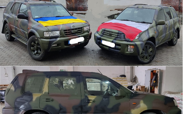 Dwa samochody w kamuflażu, jeden z flagą Ukrainy, drugi z flagą Polski.