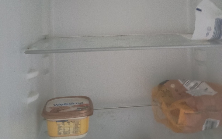 Pusta lodówka z jedynie kilkoma produktami.