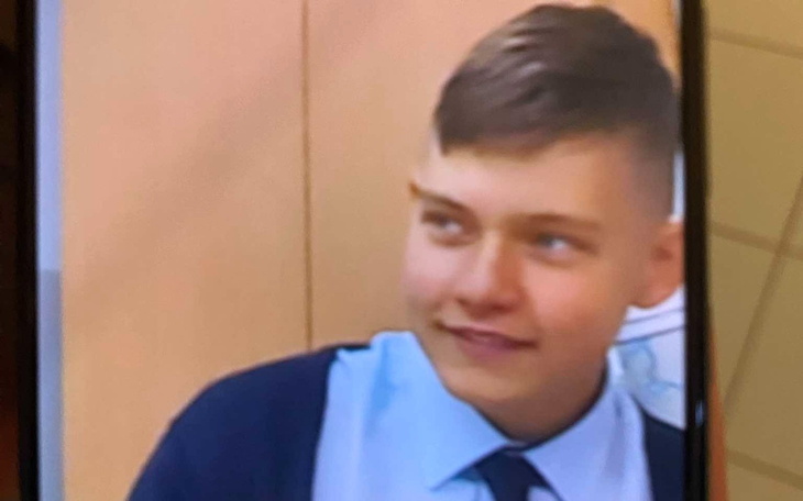 Młody mężczyzna z uśmiechem, w eleganckim stroju.