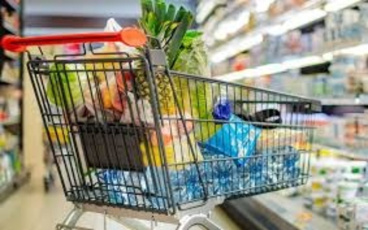 Wózek zakupowy pełen świeżych produktów spożywczych.