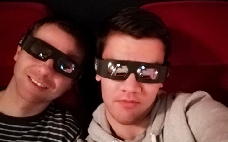 Dwaj mężczyźni w okularach 3D, gotowi na seans filmowy.