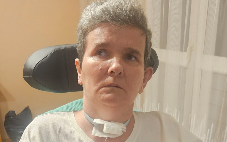 Kobieta w fotelu, z wyrazem powagi, patrząca w dal.