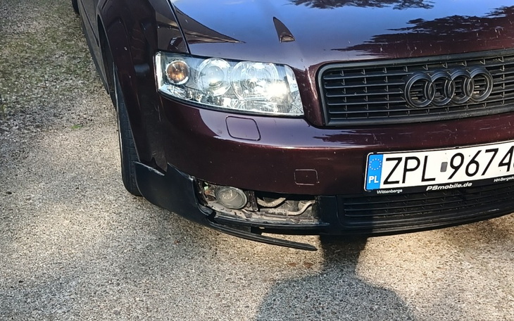 Uszkodzony przód samochodu na drodze.