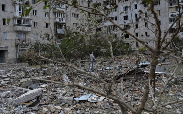 Zniszczony teren po bombardowaniu, z widocznymi ruinami budynków.