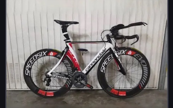 Rower wyścigowy Cannondale stoi na tle białej ściany.