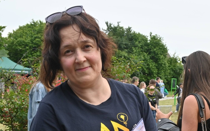 Kobieta w czarnej koszulce na wydarzeniu plenerowym.