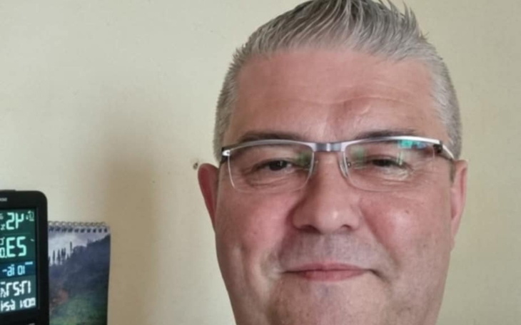 Mężczyzna z okularami, uśmiechający się do kamery.