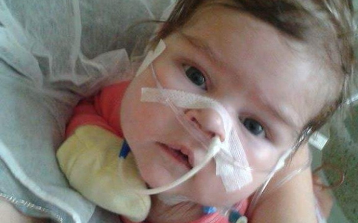 Mała dziewczynka z tlenem, patrząca z niepokojem.