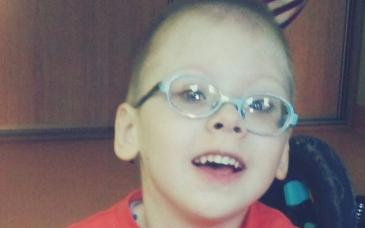 Uśmiechnięty chłopiec w okularach, radosny i szczęśliwy.