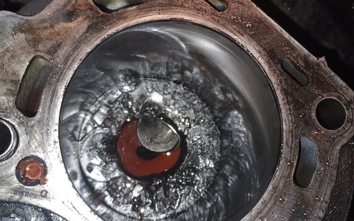 Widok na uszkodzoną część silnika, z widocznymi zanieczyszczeniami.