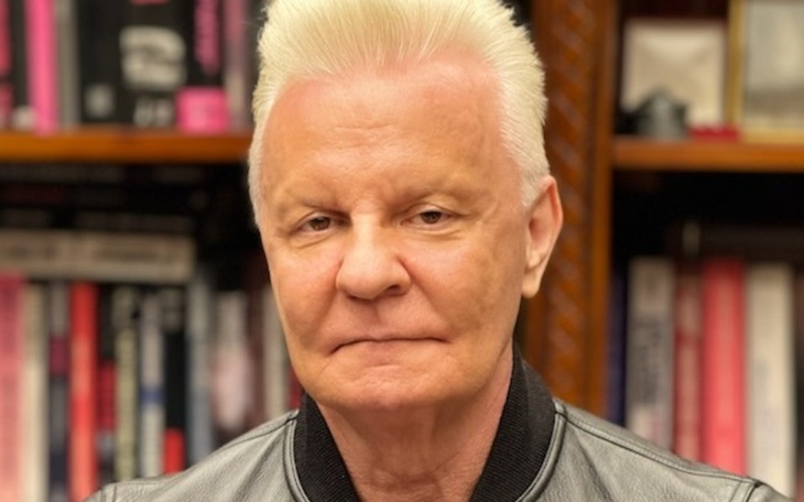 Mężczyzna w skórzanej kurtce, z poważnym wyrazem twarzy.