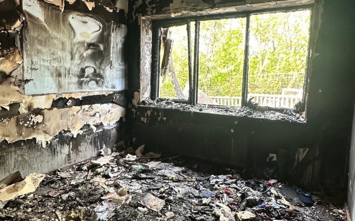 Wnętrze spalonego pomieszczenia z zniszczonymi meblami.