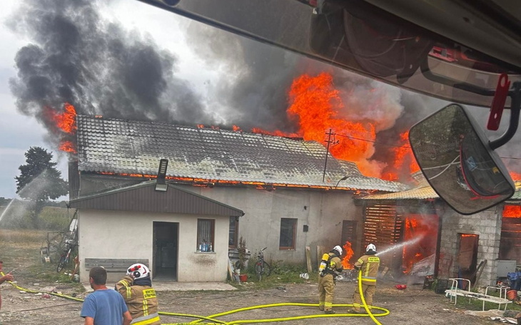 Pożar budynku, strażacy walczą z ogniem.