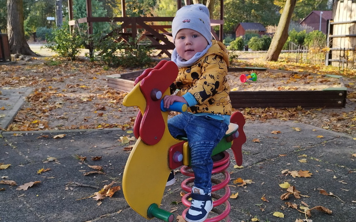 Dziecko bawiące się na huśtawce w parku.