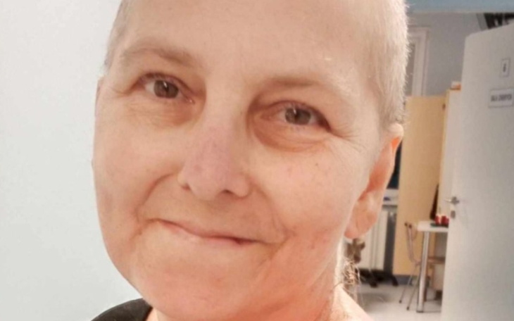 Uśmiechnięta kobieta po leczeniu, z nadzieją w oczach.