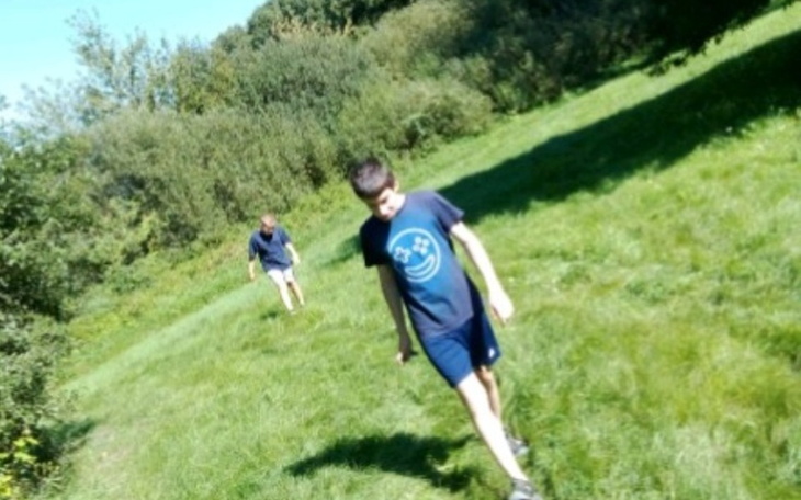 Dwóch chłopców spacerujących po zielonej łące.