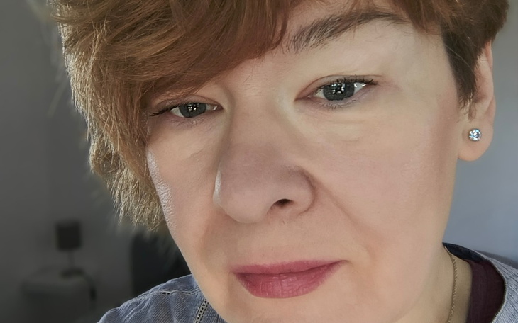 Portret kobiety z krótkimi włosami.