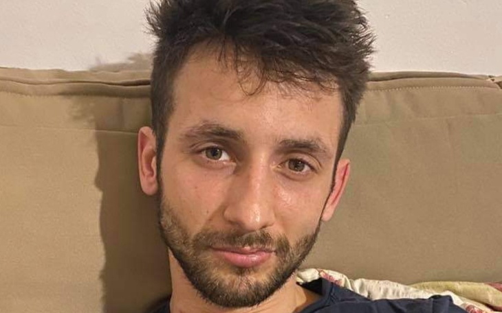 Mężczyzna z krótkimi włosami, uśmiechający się do kamery.