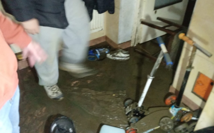 Zalane mieszkanie, z widocznymi przedmiotami na podłodze.