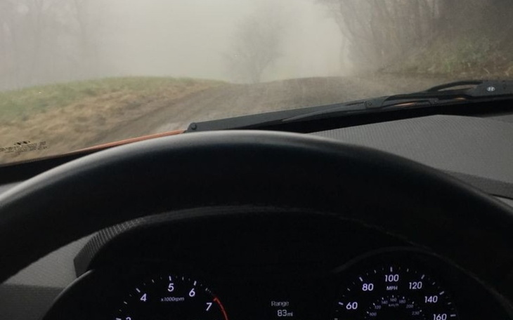 Widok z wnętrza samochodu na mglistą drogę.