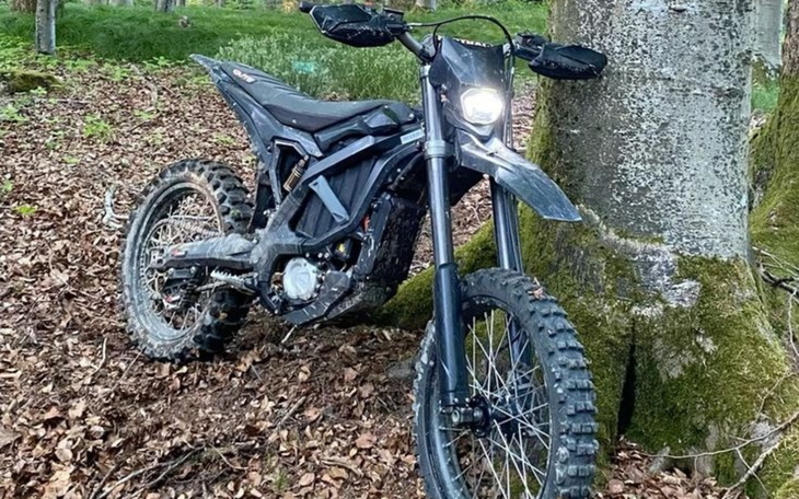Motocykl elektryczny zaparkowany w lesie.