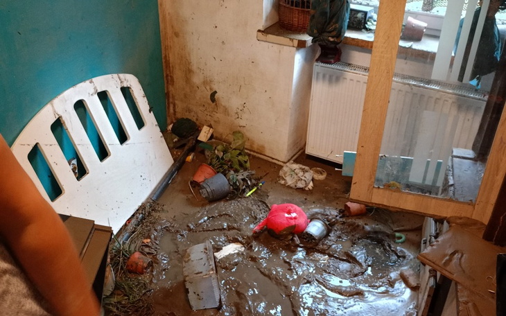Zniszczone wnętrze z bałaganem i błotem po powodzi.