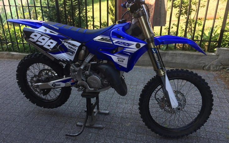 Motocykl terenowy zaparkowany na podjeździe.