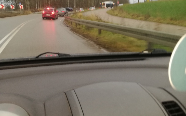 Widok z wnętrza samochodu na drogę i nadjeżdżające pojazdy.