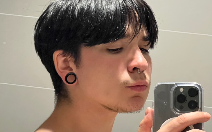 Młody mężczyzna robiący selfie w lustrze.