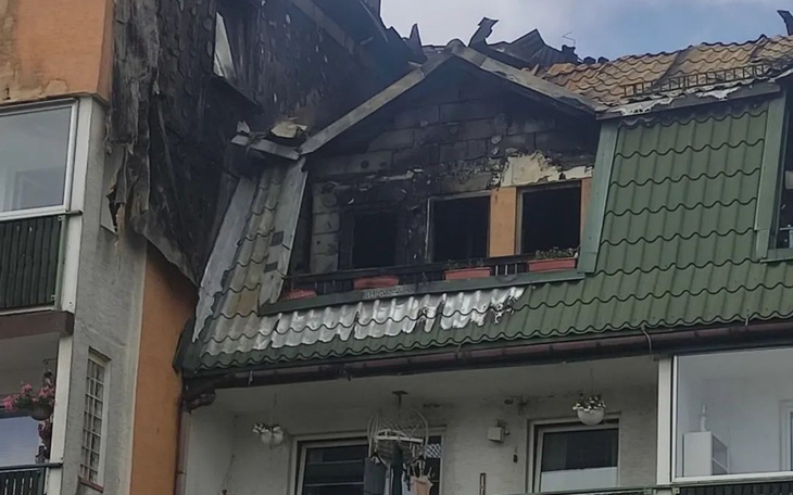 Zniszczony dach budynku po pożarze, widoczne uszkodzenia.