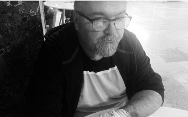 Mężczyzna w okularach, zamyślony przy stole.