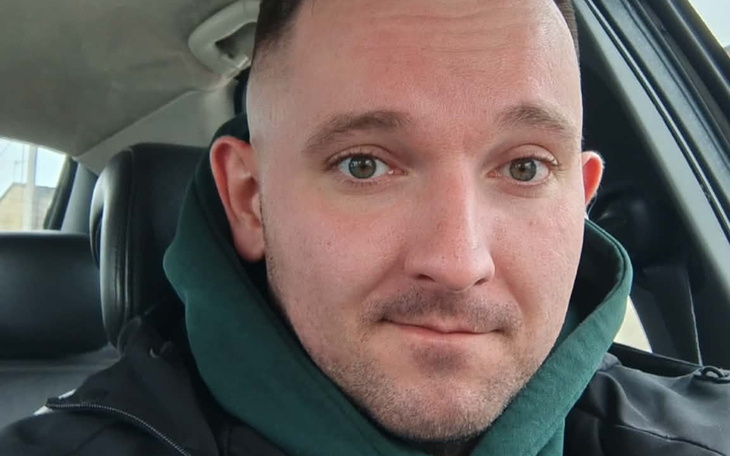 Mężczyzna w samochodzie, uśmiechający się.