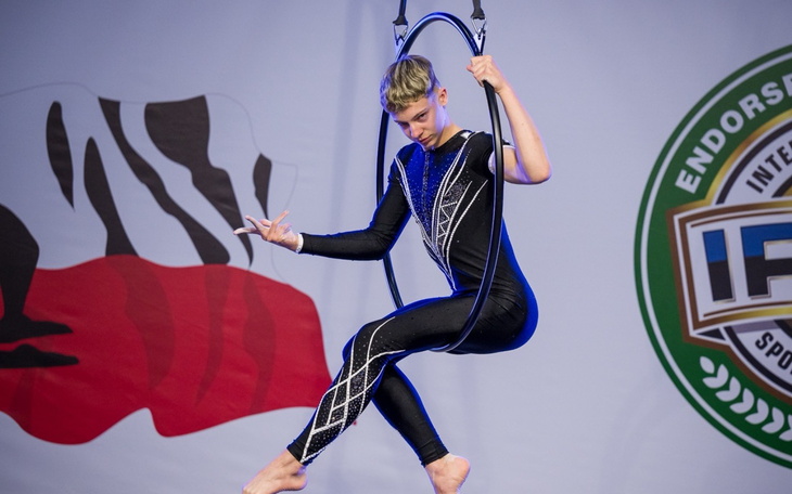 Akrobatka w kostiumie, wykonująca sztukę w powietrzu.