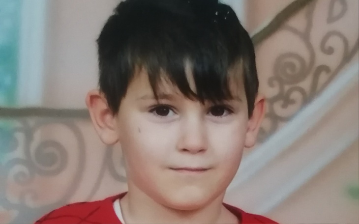 Portret chłopca w czerwonej koszulce, z krótkimi włosami.