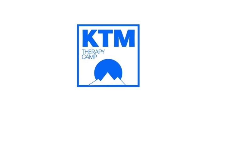 Logo obozu terapeutycznego KTM z górskim motywem.