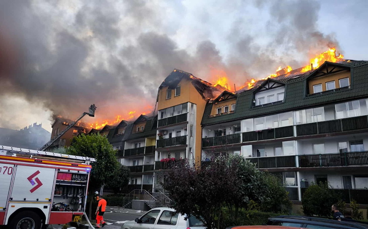 Pożar na dachu budynku, strażacy w akcji.