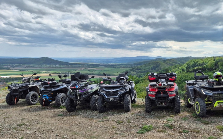 Grupa quadów na tle malowniczej doliny, w pięknej scenerii.