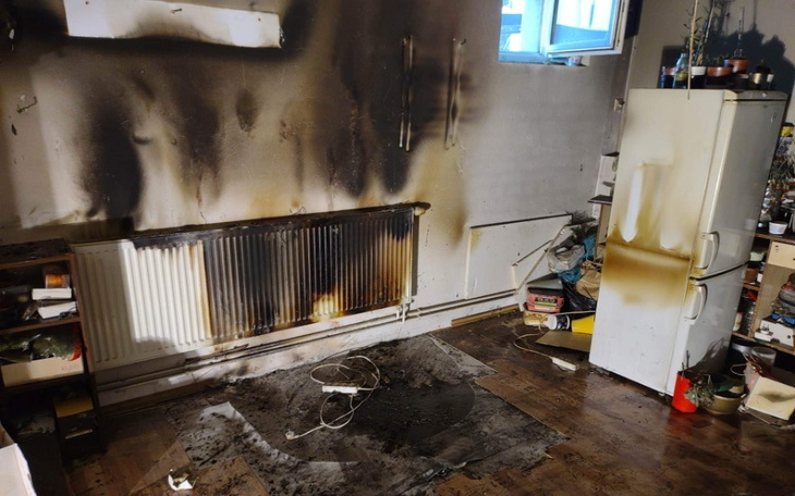 Zniszczona kuchnia po pożarze, z popalonymi ścianami.