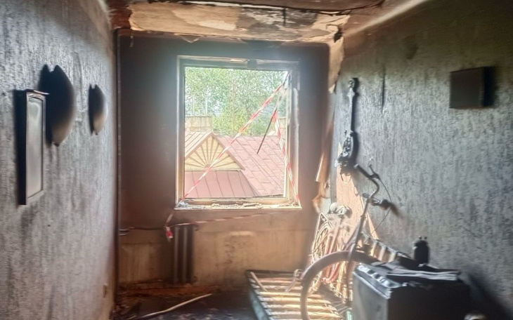 Zniszczony pokój po pożarze, z widokiem na okno.