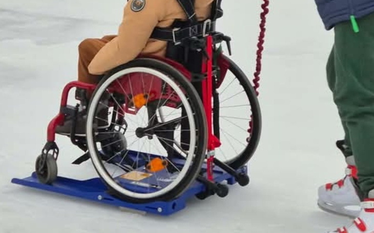 Dziecko na wózku inwalidzkim, przygotowane do jazdy na lodzie.