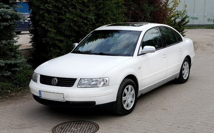 Biały samochód osobowy zaparkowany na zewnątrz.