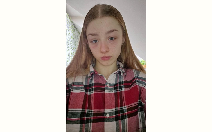 Młoda dziewczyna w koszuli w kratę, z zamyśloną miną.