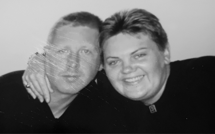 Para przytulająca się na zdjęciu w czerni i bieli.