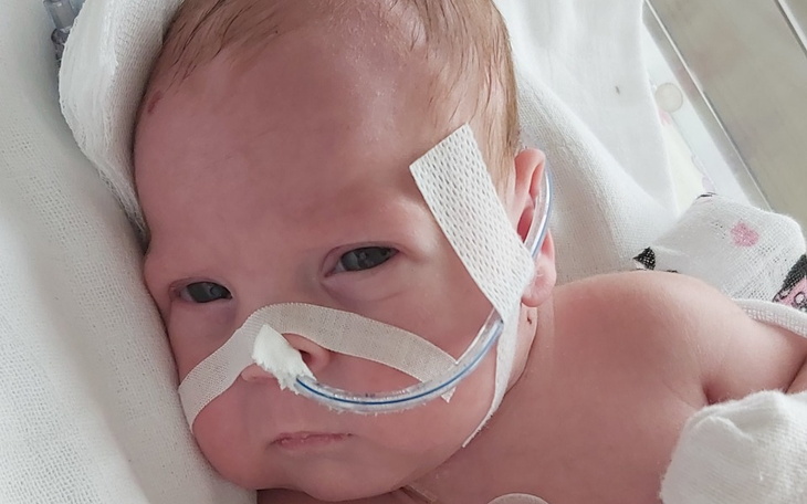 Noworodek w inkubatorze z rurkami tlenowymi.