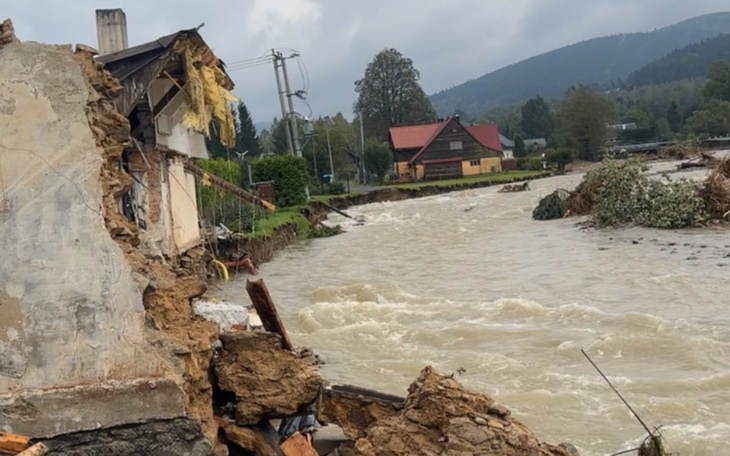 Zniszczony budynek nad rzeką, z widokiem na krajobraz.