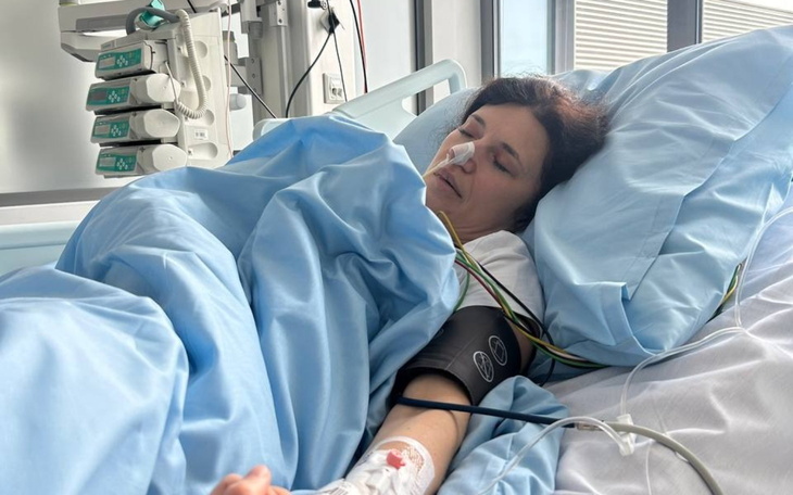 Kobieta leżąca w szpitalnym łóżku, podłączona do aparatury medycznej.