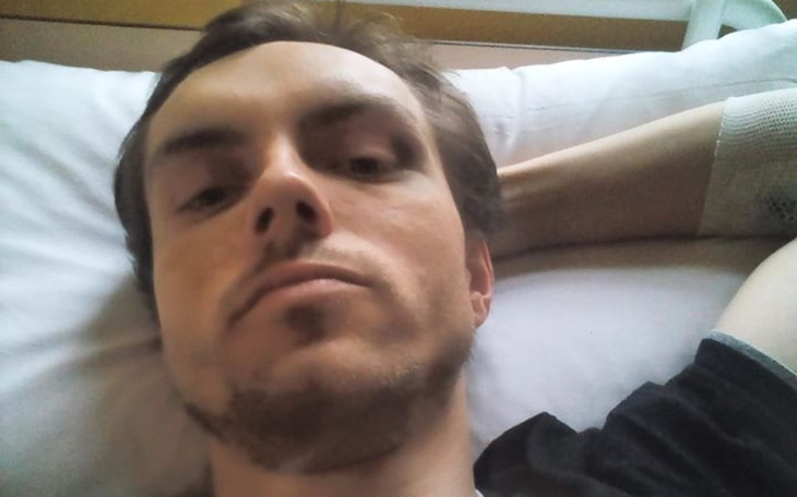 Mężczyzna leżący w łóżku, z widocznym zmęczeniem na twarzy.